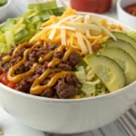 Low-carb Big Mac bowl recipe with ground beef, lettuce, cheese, pickles, and special sauce